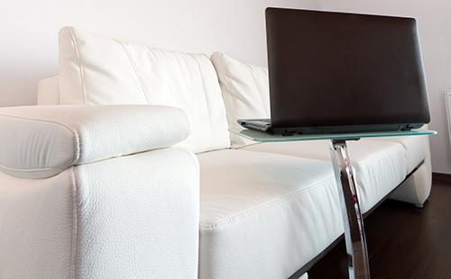 Es agradable trabajar con una computadora portátil en un sofá de cuero blanco