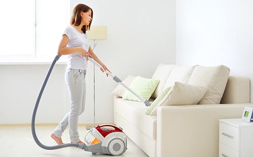Girl in white and with a vacuum cleaner