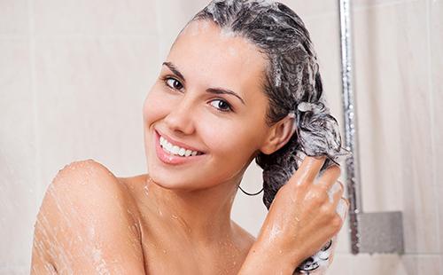 Femme se lave les cheveux avec un shampooing