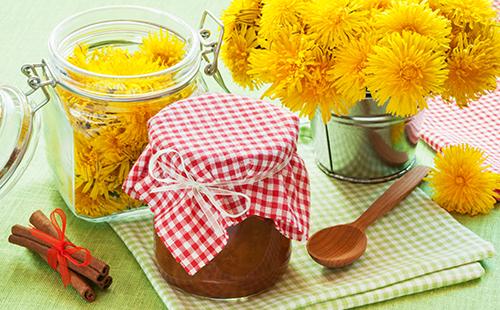 Jar of jam and a bouquet of dandelions