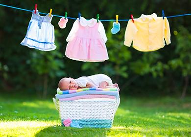 El bebé yace sobre una pila de ropa limpia