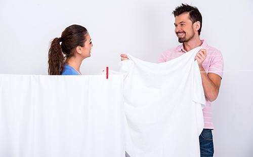 Couple accroche les draps lavés