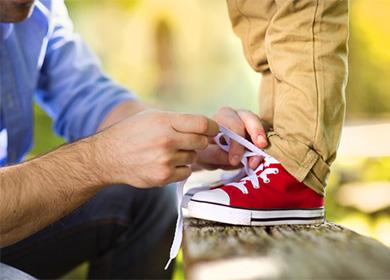 Father tying shoelaces for his son
