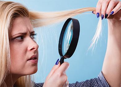 Mujer mirando el cabello a través de una lupa
