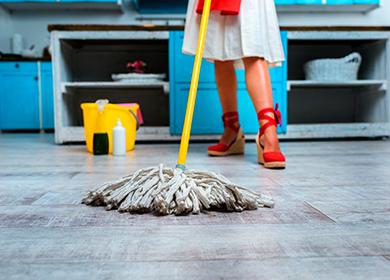Female legs in red shoes, a yellow bucket and a mop