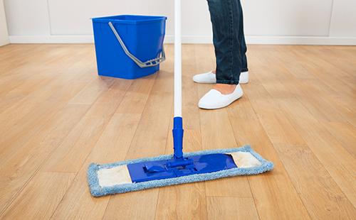 Woman with a mop on a wooden floor