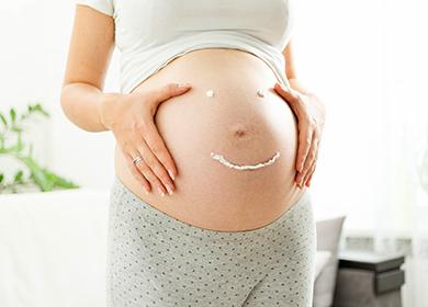 Émoticône crémeux sur un ventre de femme enceinte