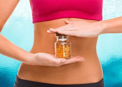 Jar with pills on the background of the female abdomen