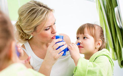 Maman aide bébé à se laver le nez