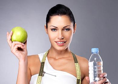 Beautiful girl with a green apple and a bottle of water