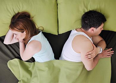 Woman and man turned away from each other in bed