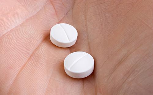 Pilules blanches dans les mains