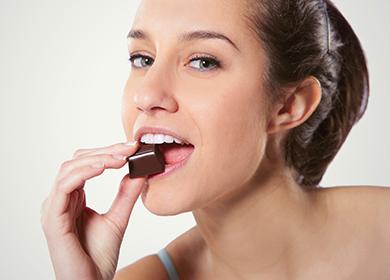 Woman eating a cube of chocolate