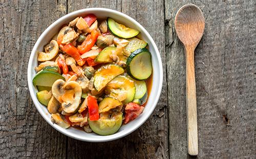 Assorted vegetables in a plate with a spoon