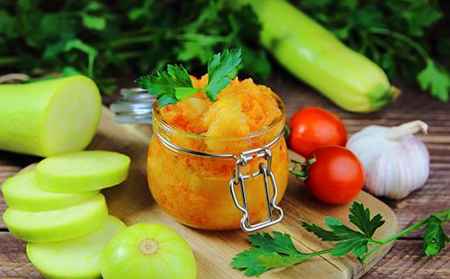 Conserves de légumes dans un bocal, tranches de courgettes, tomates cerises et persil