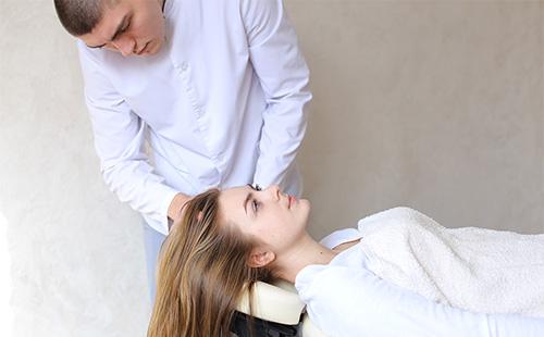 Un hombre le hace un masaje en la cabeza a una mujer