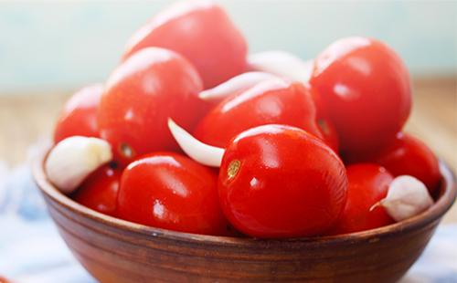 Tomatoes with garlic in a wooden bowl