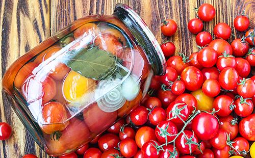 Tomates en escabeche con cebolla en una jarra