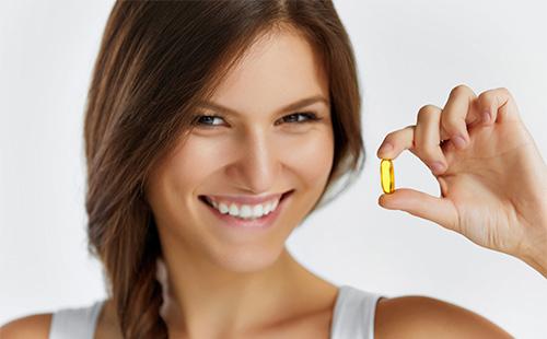 Woman holds fish oil capsule