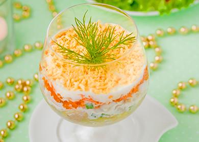 Puff salad with carrots, mayonnaise, cheese and herbs in a glass