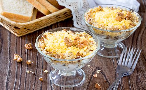 Salad in a bowl sprinkled with cheese and walnuts