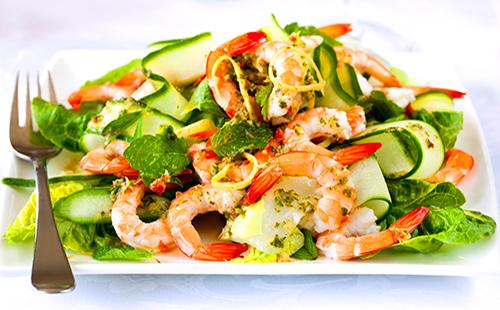 Salade aux crevettes, concombres et herbes sur une assiette