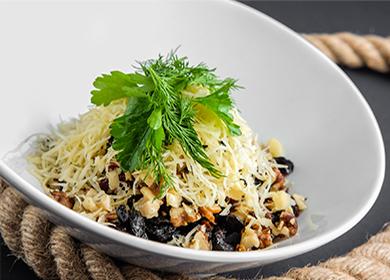Puff salad with chicken, cheese and prunes in a plate