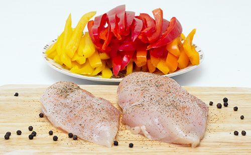 Chicken fillet and chopped colorful peppers