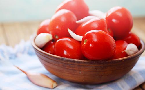 Tomatoes with garlic in a wooden cup