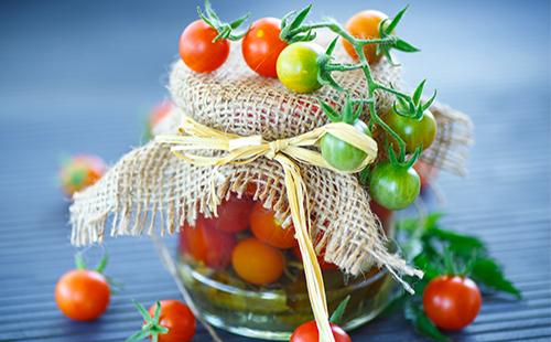 Green and red cherry tomatoes in a jar