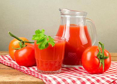 Tomato juice in a jug and a glass on a tablecloth