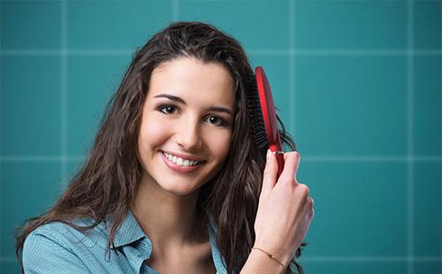 Young woman combing her hair