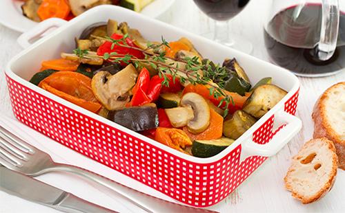 Baked eggplant with champignons and carrots on the table