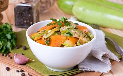 Courgettes avec carottes, ail et herbes dans une assiette