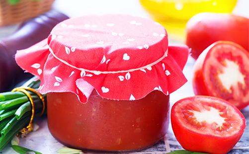 Pâte de tomate dans un bocal et tranches de tomates