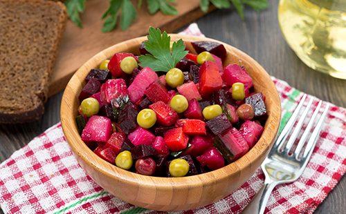 Beetroot salad with peas in a wooden bowl