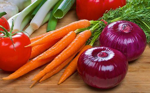 Un bouquet de carottes et deux oignons violets