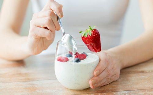 Woman eating yogurt with berries