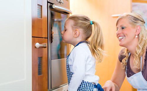 Mom and daughter bake in the oven