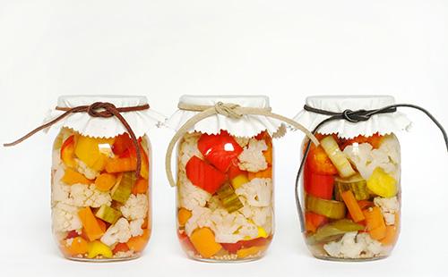 Three jars with cauliflower and other vegetables salad