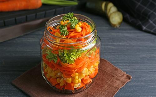Ensalada con zanahorias y guisantes en una jarra