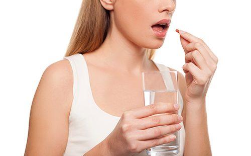 Girl getting ready to swallow a capsule