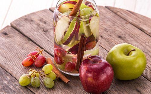 Manzanas y uvas en una mesa de madera