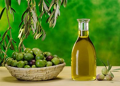 Olive oil in a bottle and a plate of olives