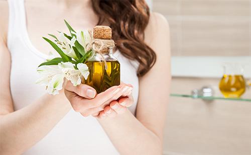 Olive oil in a jar in the hands of a girl
