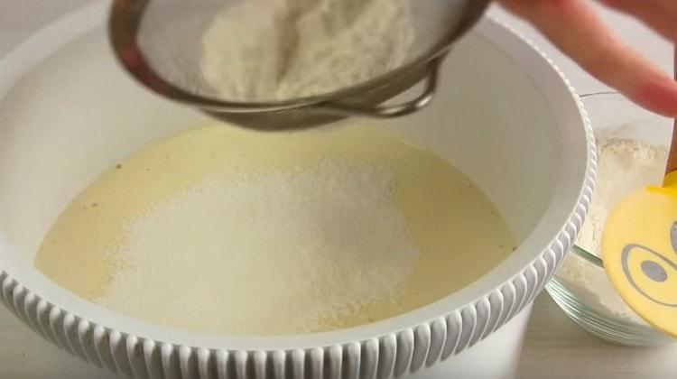 Tamiser la farine dans la masse d'oeufs et mélanger doucement.