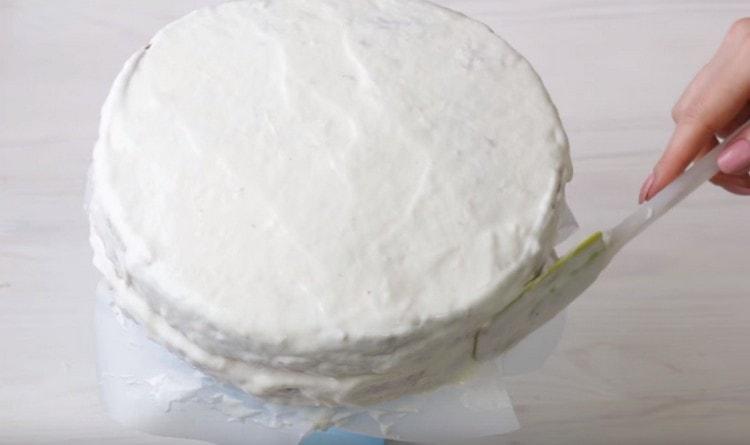 Niveler la crème sur le dessus et les côtés du gâteau.