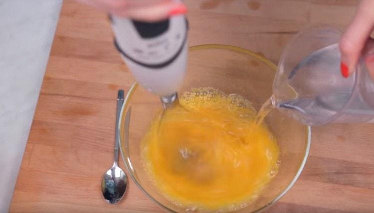 En battant les œufs avec du sel, ajoutez-y de l'eau.