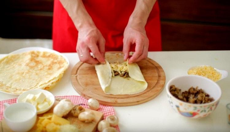 Wrap pancakes with mushrooms and cheese in envelopes.