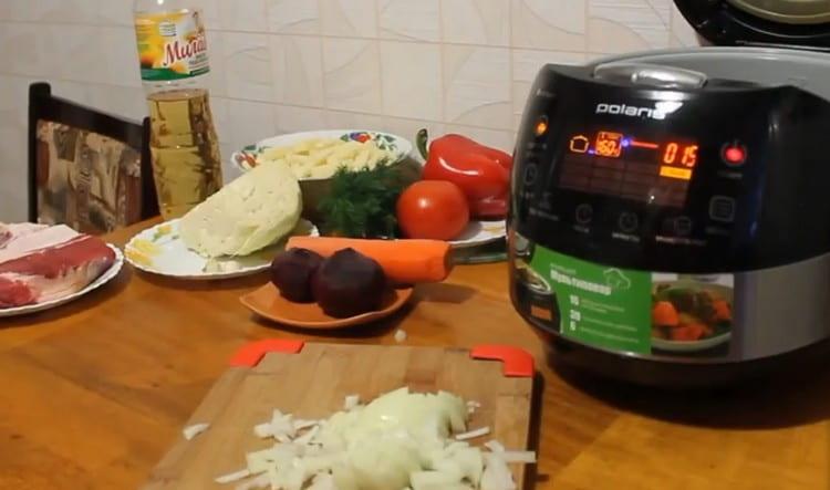 Para comenzar, encienda la olla de cocción lenta y pique finamente la cebolla.